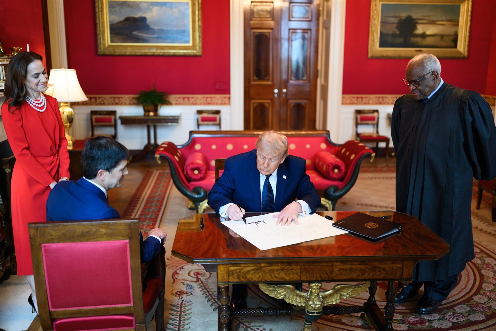 President Donald Trump signs the commission for incoming Federal Reserve Chair Kevin Warsh in the Red Room of the White House