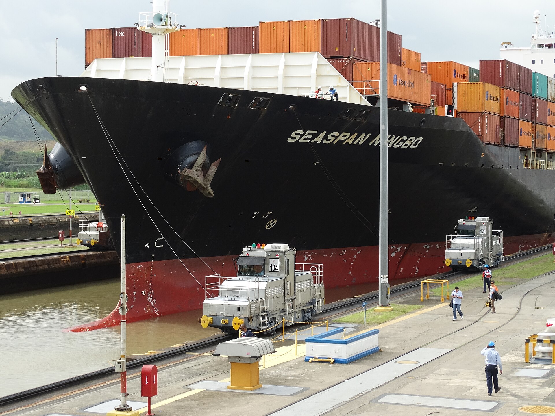 Towing locomotives guiding a container ship through the Miraflores Locks
