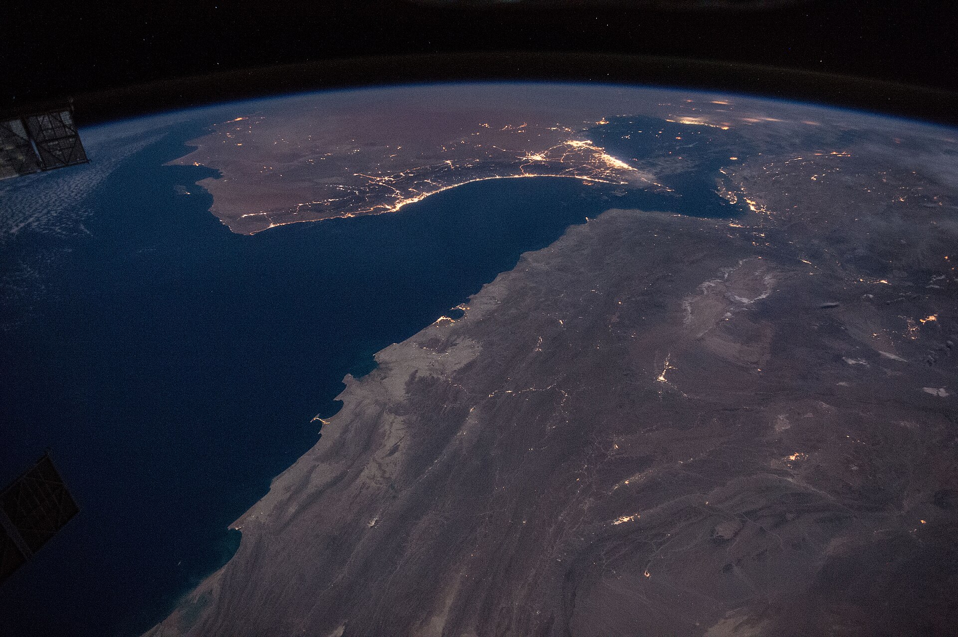Night satellite view of the Gulf of Oman and Strait of Hormuz, with the lights of Muscat, Dubai, Abu Dhabi and Doha visible