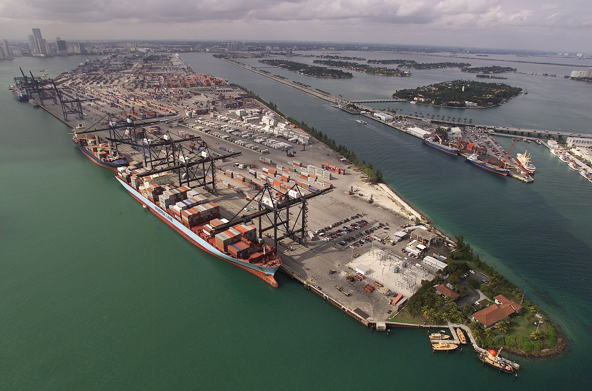 Aerial view of a US container port with rows of stacked shipping containers and gantry cranes